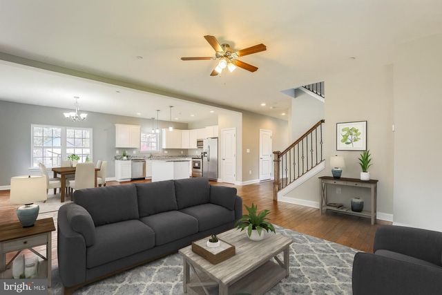 a living room with furniture and a view of kitchen