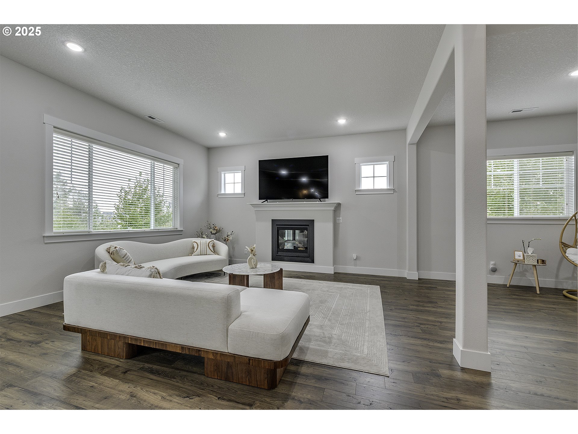 15080 Northwest Legend Street Portland, OR 97229 - Photo 6 of 38 a living room with furniture a fireplace and a flat screen tv
