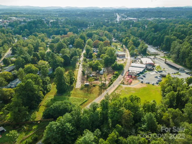 an aerial view of residential house with outdoor space and trees all around