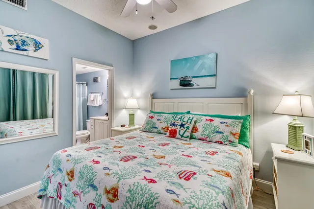 a bedroom with a bed and a lamp on dresser