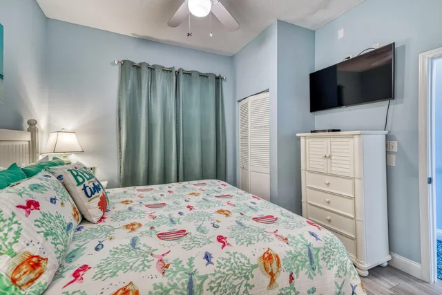 a bedroom with a bed and a flat tv screen on dresser