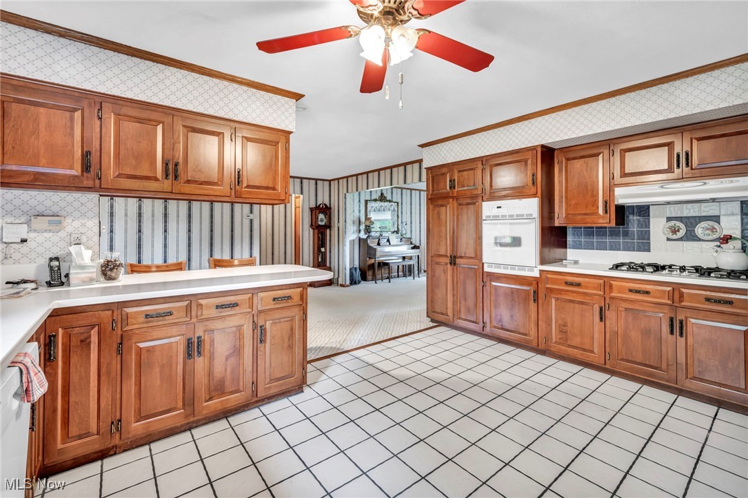 9184 Zimmerman Road Homerville, OH 44235 - Photo 28 of 50 Kitchen featuring ceiling fan, light tile patterned floors, backsplash, ornamental molding, and white appliances