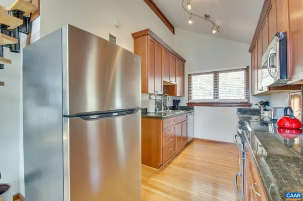 a kitchen with stainless steel appliances granite countertop a stove a sink and a microwave