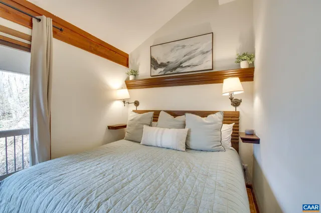 a bedroom with a bed and painting on the wall