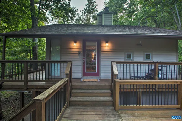 a view of balcony with wooden floor outdoor seating and yard in the back