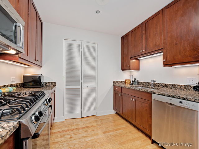 60 East Monroe Street, Unit 1906 Chicago, IL 60603 - Photo 14 of 20 a kitchen with stainless steel appliances granite countertop a stove and a sink