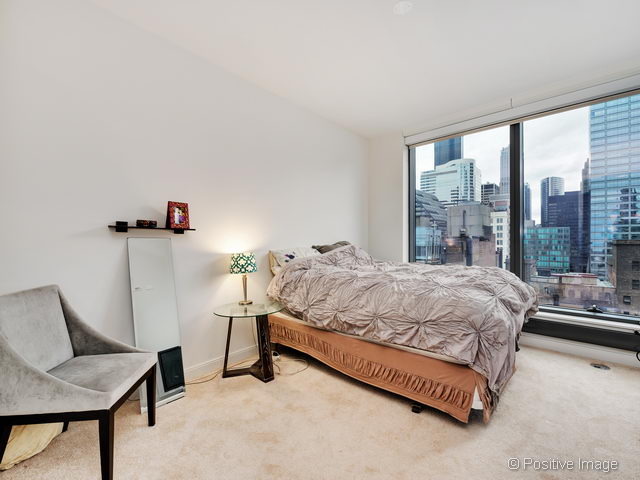 60 East Monroe Street, Unit 1906 Chicago, IL 60603 - Photo 15 of 20 a bed sitting in a bedroom next to a window