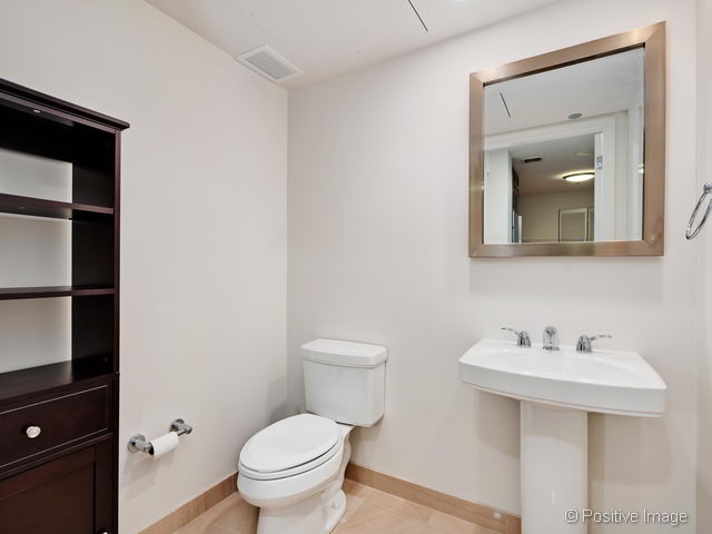 60 East Monroe Street, Unit 1906 Chicago, IL 60603 - Photo 17 of 20 a bathroom with a toilet a sink and mirror
