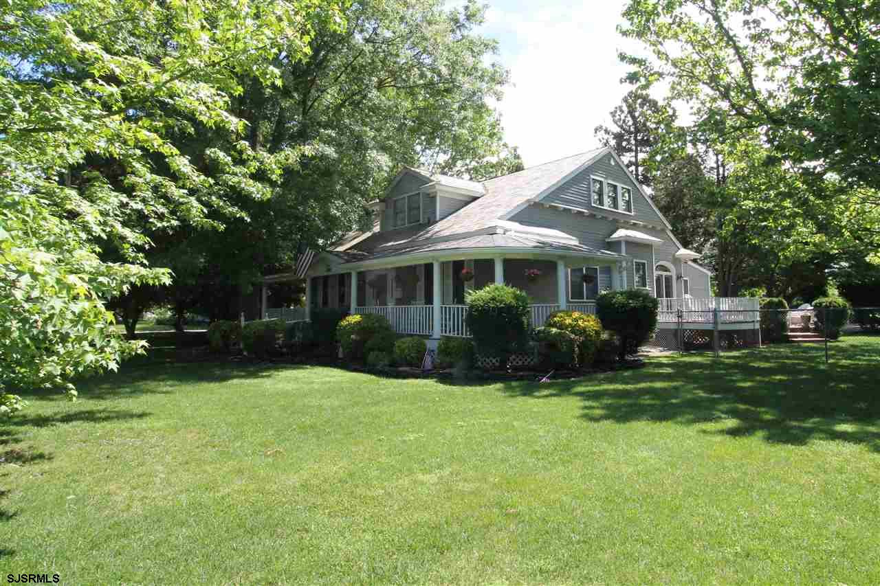 a front view of a house with a yard and trees