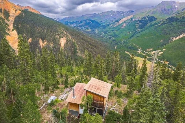 a aerial view of a house with a yard and mountain view in back