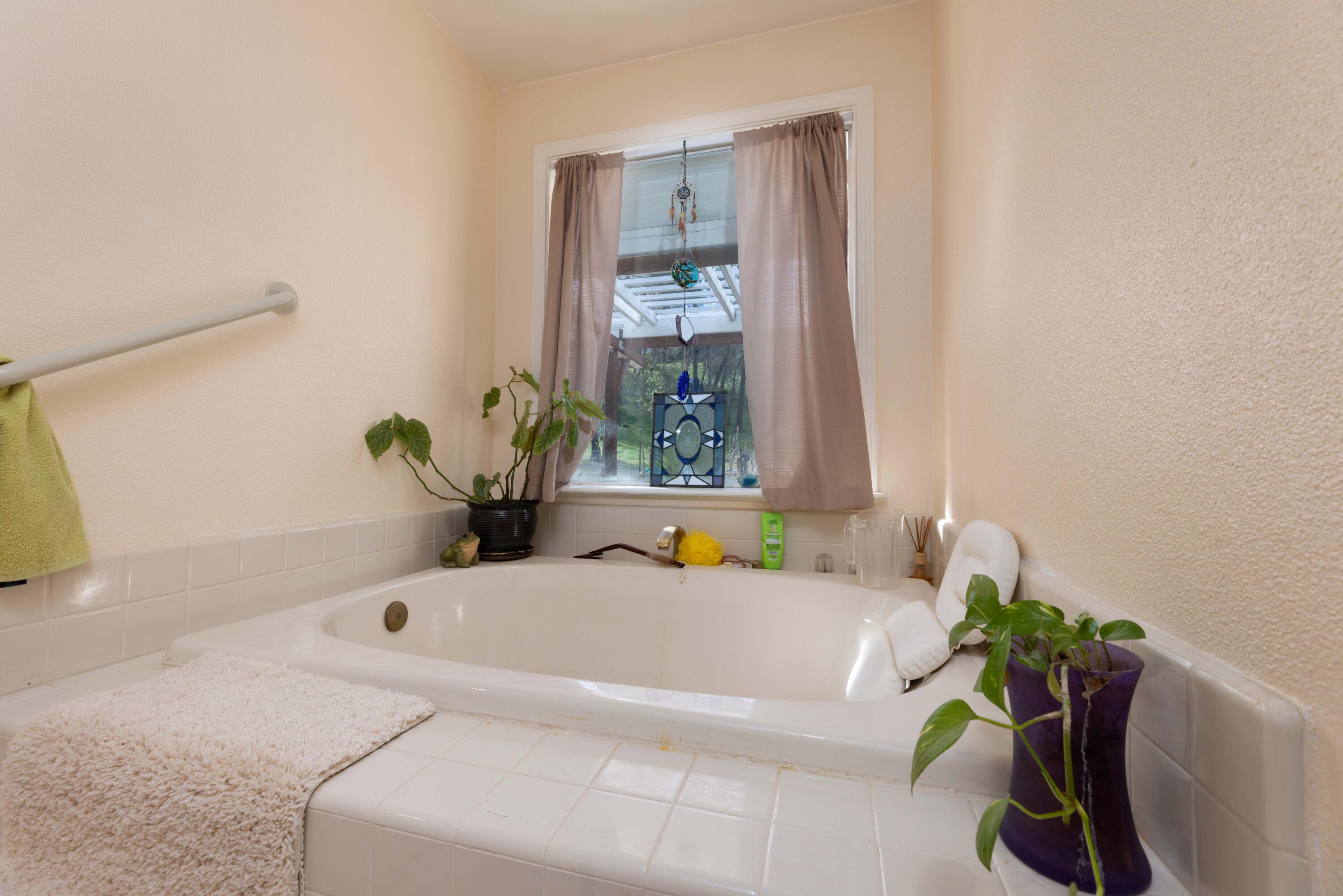 8790 Redbank Road Redding, CA 96001 - Photo 14 of 21 a bath tub sitting in a bathroom next to a window
