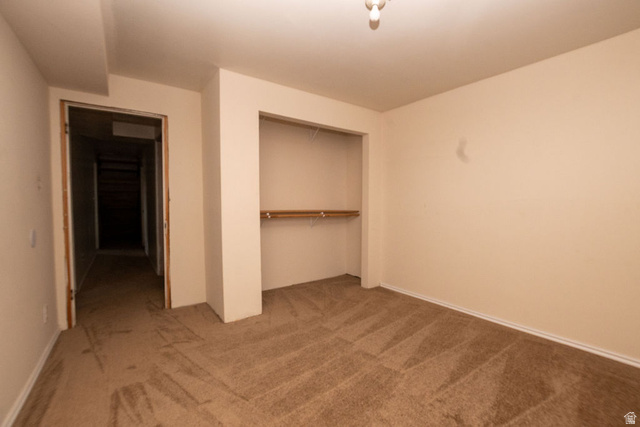 570 West Main Street Beaver, UT 84713 - Photo 26 of 43 Carpeted room featuring a built-in closet with shelving and hanging rods, neutral wall color, and white baseboards
