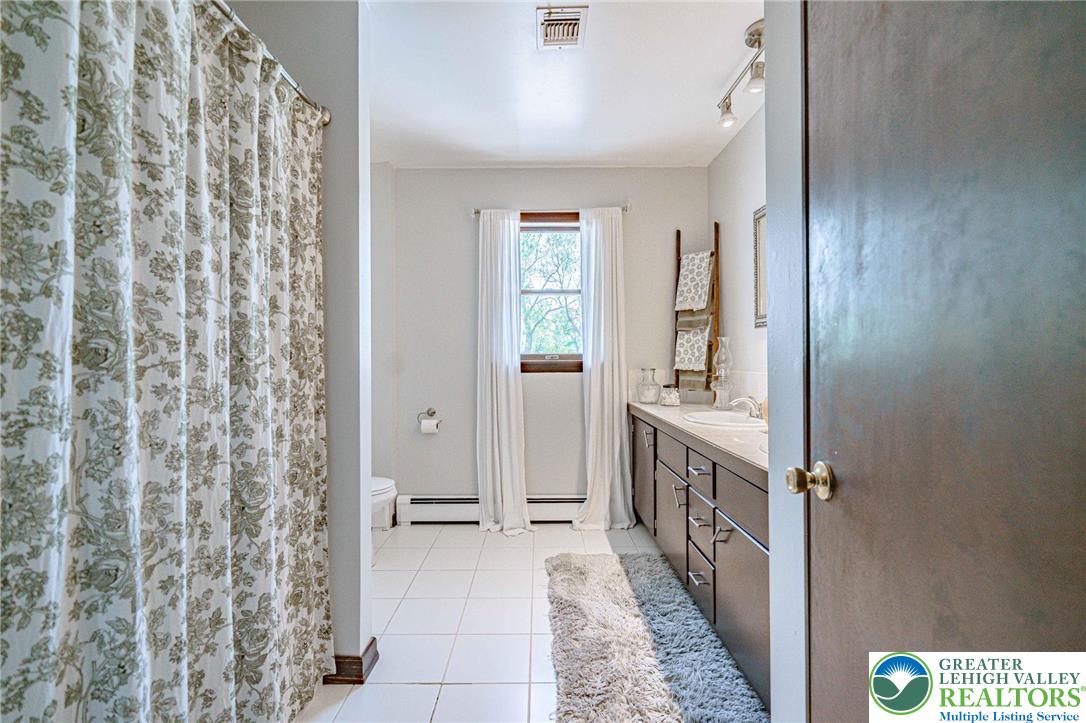 3857 Friedens Road Slatington, PA 18080 - Photo 45 of 75 This bright bathroom features a vanity with ample storage and sleek tile flooring.