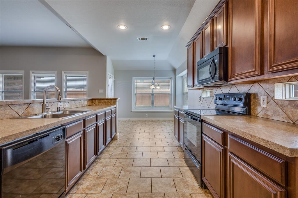145 Mill Street Anna, TX 75409 - Photo 11 of 25 a kitchen with stainless steel appliances granite countertop a sink stove and cabinets