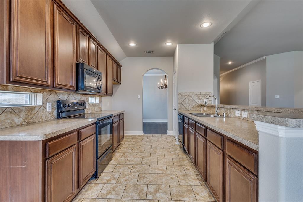 145 Mill Street Anna, TX 75409 - Photo 10 of 25 a large kitchen with stainless steel appliances granite countertop a sink stove and refrigerator