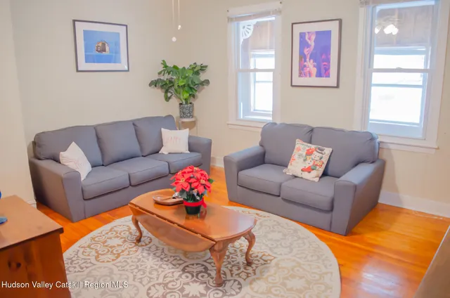 a living room with furniture and a wooden floor