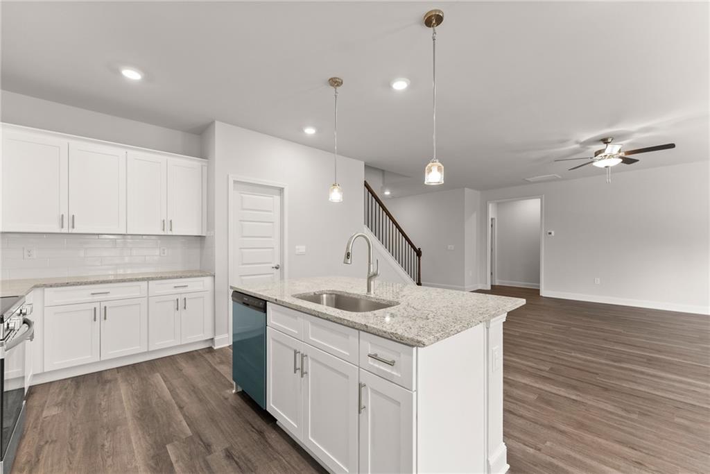 642 Bald Ridge Circle Demorest, GA 30535 - Photo 4 of 18 a kitchen with a sink dishwasher and white cabinets with wooden floor