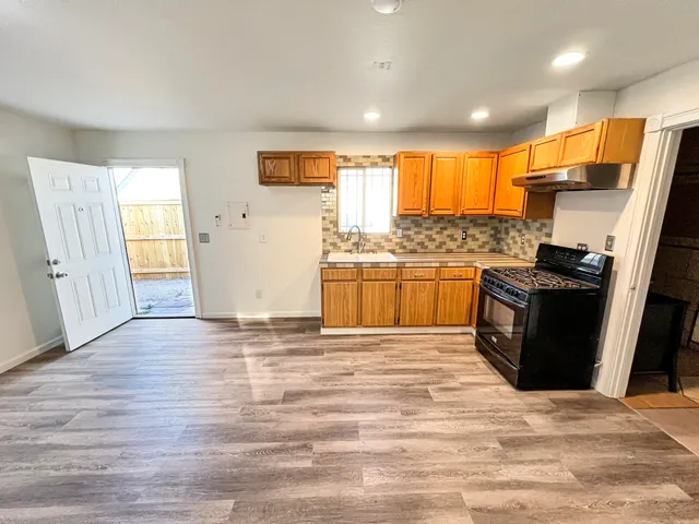 a kitchen with stainless steel appliances granite countertop a refrigerator and a stove top oven