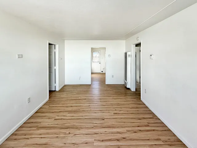 a view of a hallway with wooden floor
