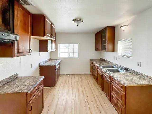 a kitchen with granite countertop a sink stove and wooden cabinets
