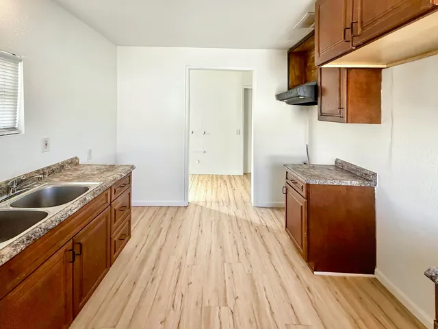 a kitchen with a sink and wooden floor