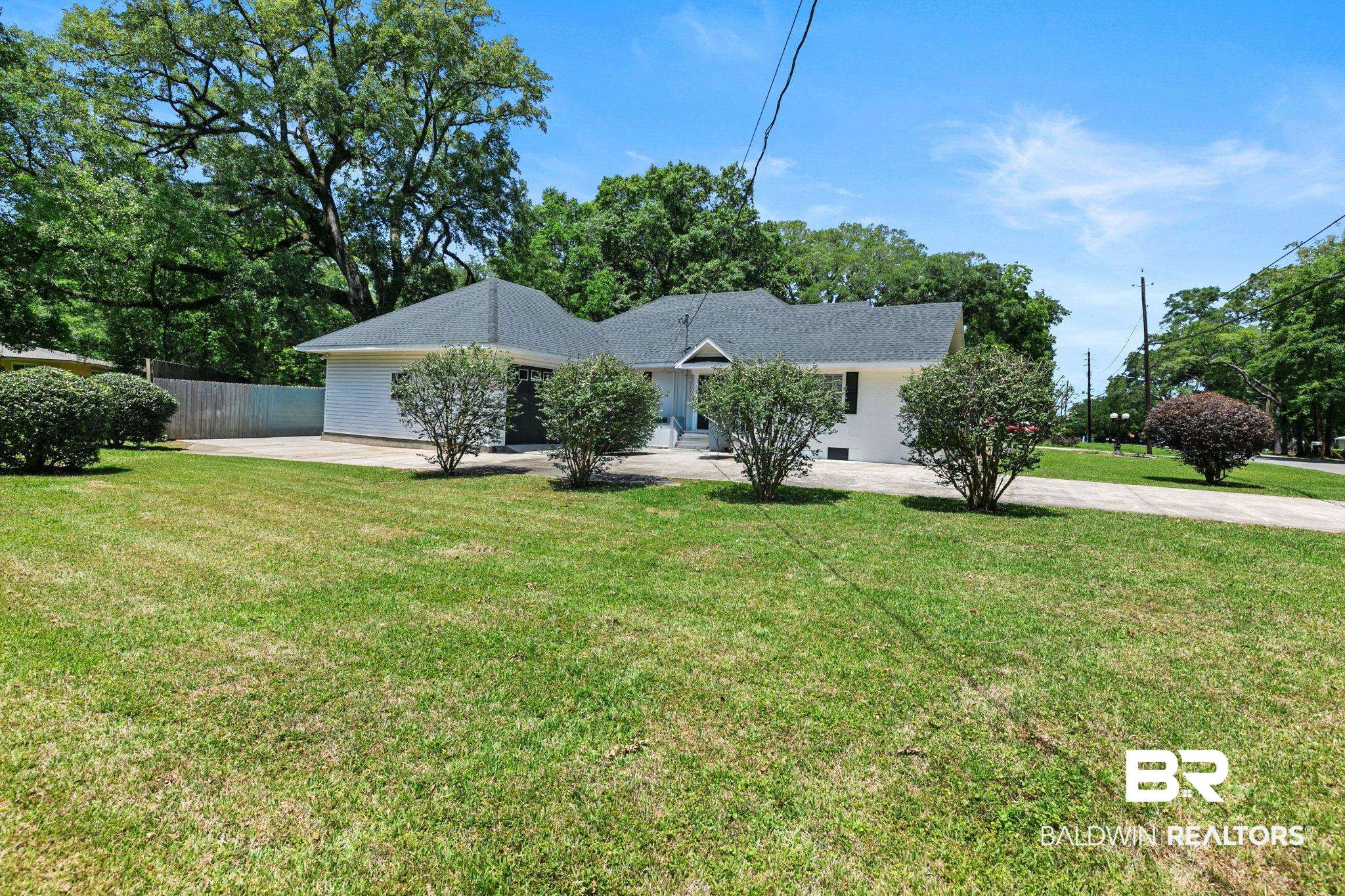 927 Cleveland Road Saraland, AL 36571 - Photo 64 of 80 Single-story residence featuring a white exterior, dark shingle roofing, and a concrete driveway