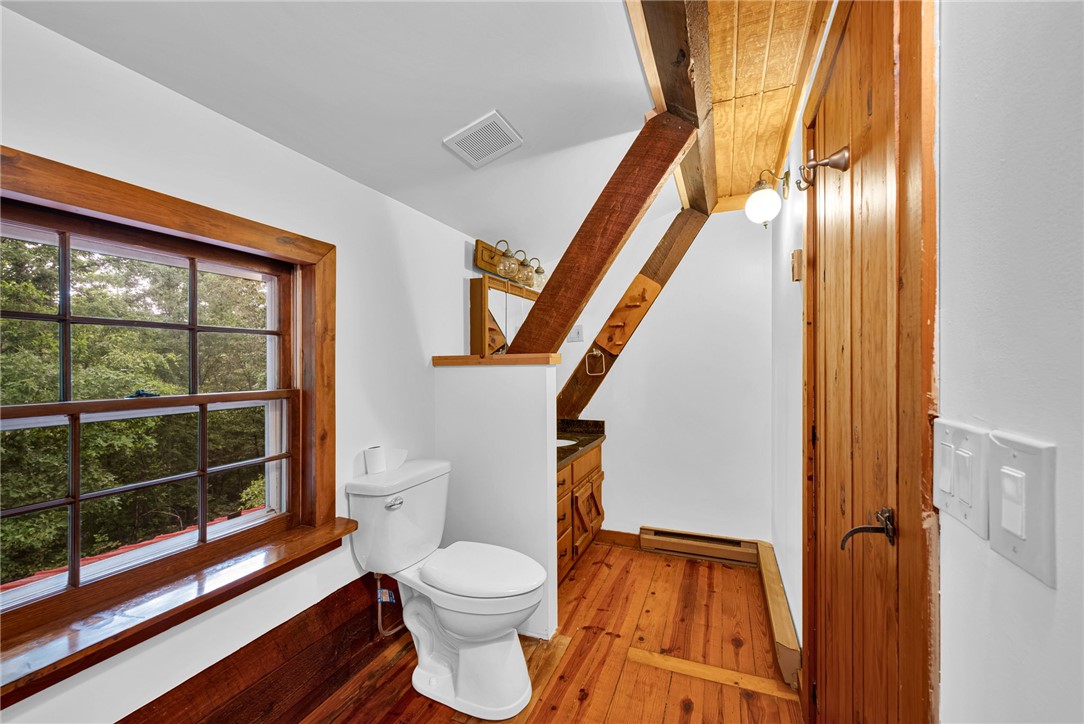 237 Spring Valley Road Liberty, SC 29657 - Photo 17 of 50 Natural wood floors and exposed beams create a rustic charm in this cozy bathroom.