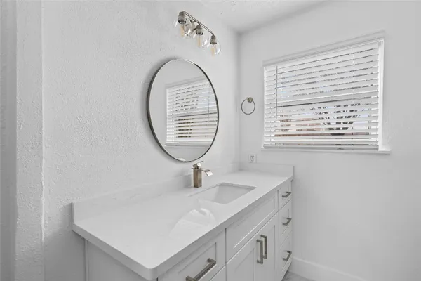 a bathroom with a sink a mirror and a window