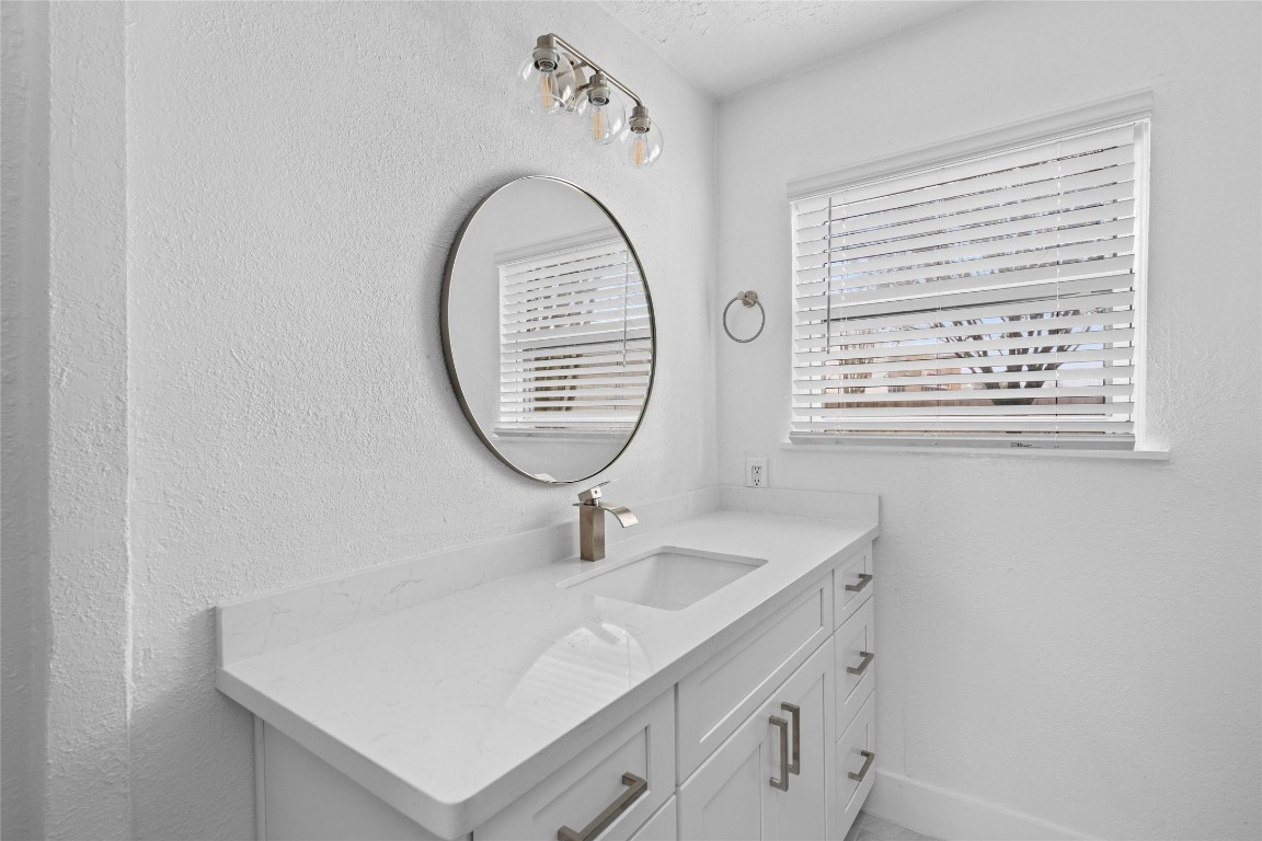 4947 Cheena Drive Houston, TX 77096 - Photo 13 of 18 a bathroom with a sink a mirror and a window