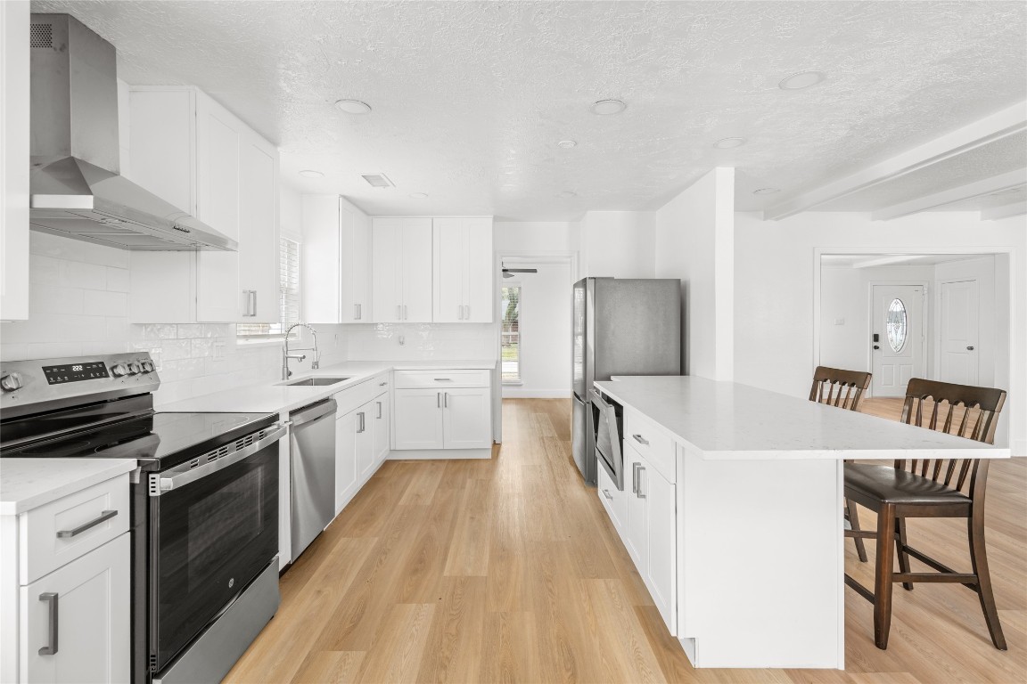 4947 Cheena Drive Houston, TX 77096 - Photo 5 of 18 a kitchen with stainless steel appliances a white cabinets and wooden floor
