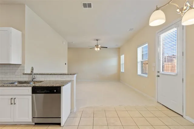a kitchen with granite countertop white cabinets and appliances