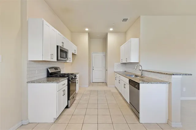 a kitchen with stainless steel appliances granite countertop a sink stove and cabinets