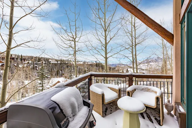 a balcony with couple of chairs and a swing