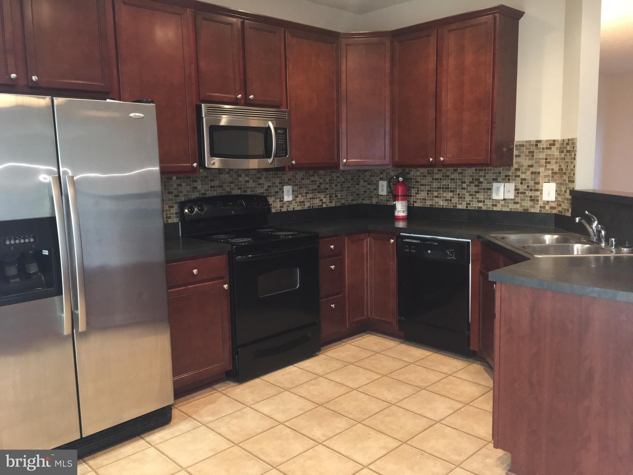 9609 Davison Road Baltimore, MD 21220 - Photo 4 of 21 a kitchen with stainless steel appliances granite countertop a refrigerator and a sink