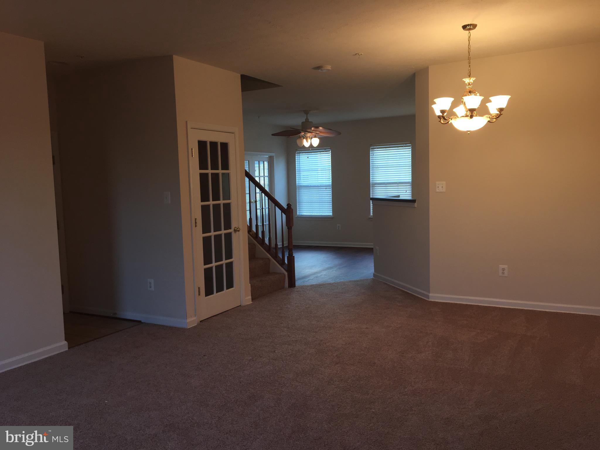 9609 Davison Road Baltimore, MD 21220 - Photo 5 of 21 an empty room with stairs and wooden floor