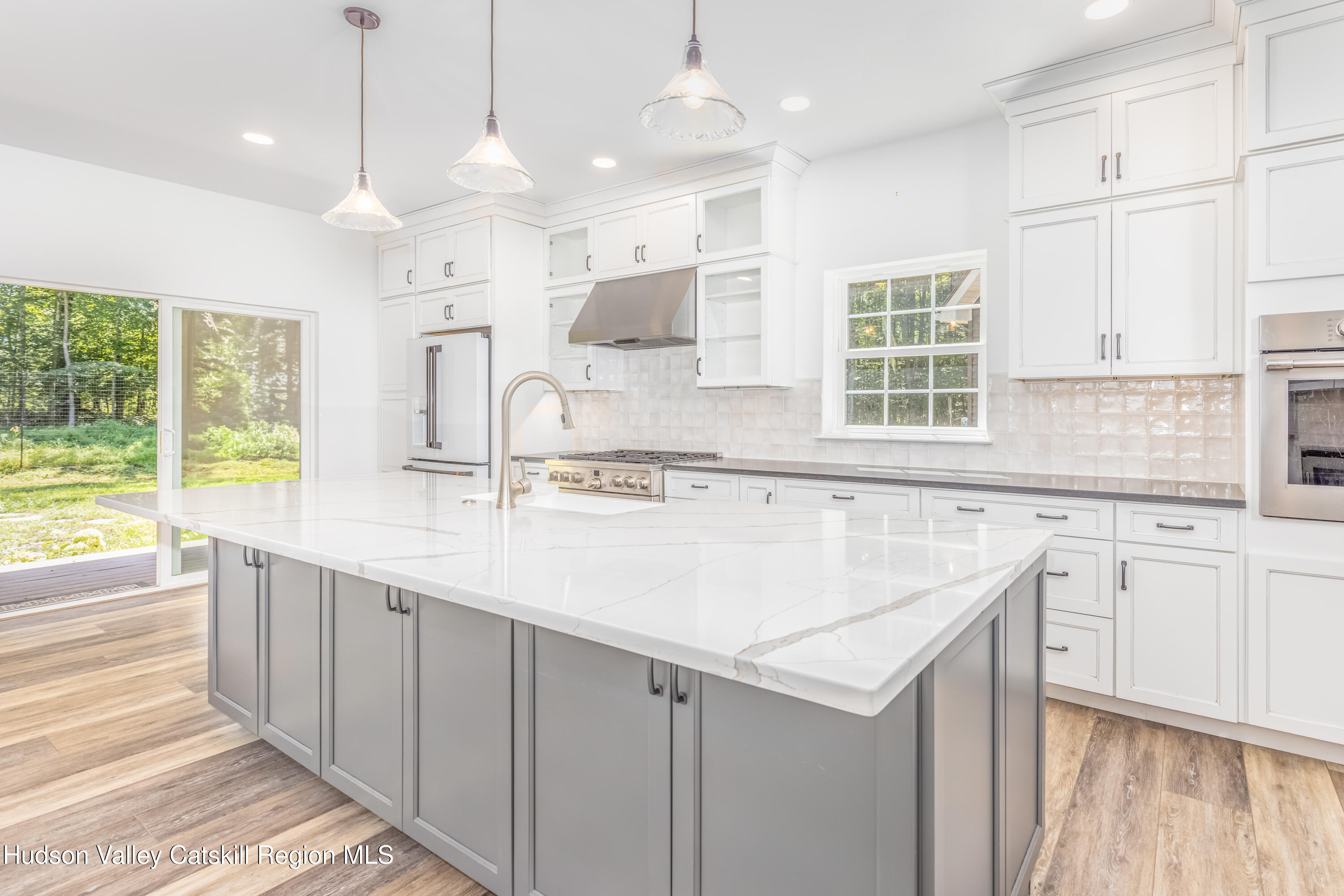 621 Decker Road Wallkill, NY 12589 - Photo 16 of 44 a kitchen with granite countertop a sink and white cabinets with wooden floor