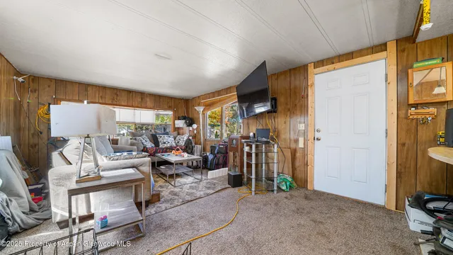 a living room with furniture a flat screen tv and a window