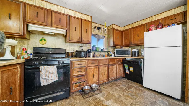 a kitchen with stainless steel appliances granite countertop a refrigerator a stove a sink and a microwave