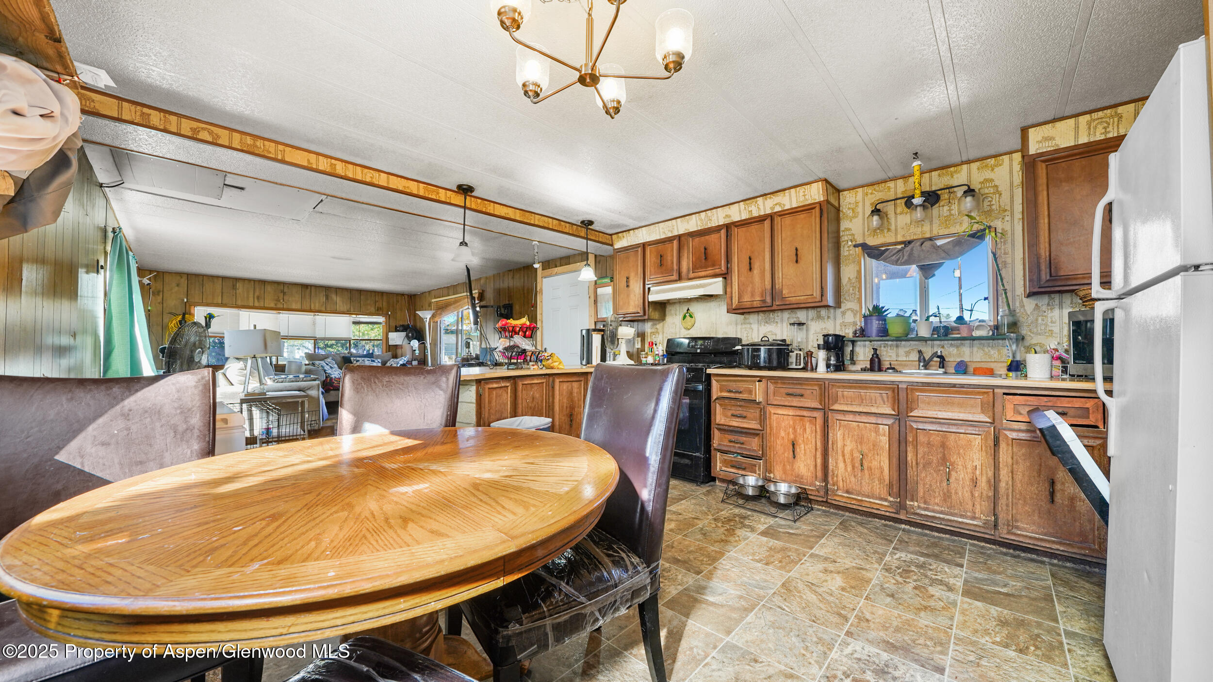 1501 Railroad Avenue, Unit 37 Rifle, CO 81650 - Photo 8 of 18 a kitchen with stainless steel appliances kitchen island granite countertop a table chairs and a wooden cabinets