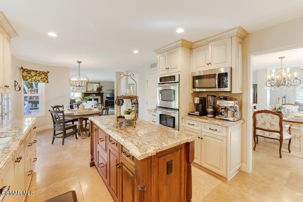 4051 Doneva Road Moorpark, CA 93021 - Photo 13 of 52 a kitchen with stainless steel appliances kitchen island granite countertop a stove top oven a sink a dining table and chairs