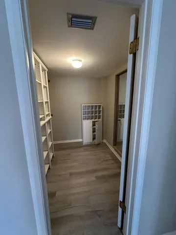 a view of a hallway with wooden floor and staircase