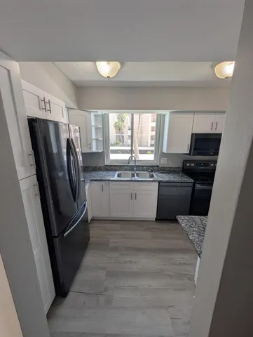 a kitchen with granite countertop a sink and a stove top oven