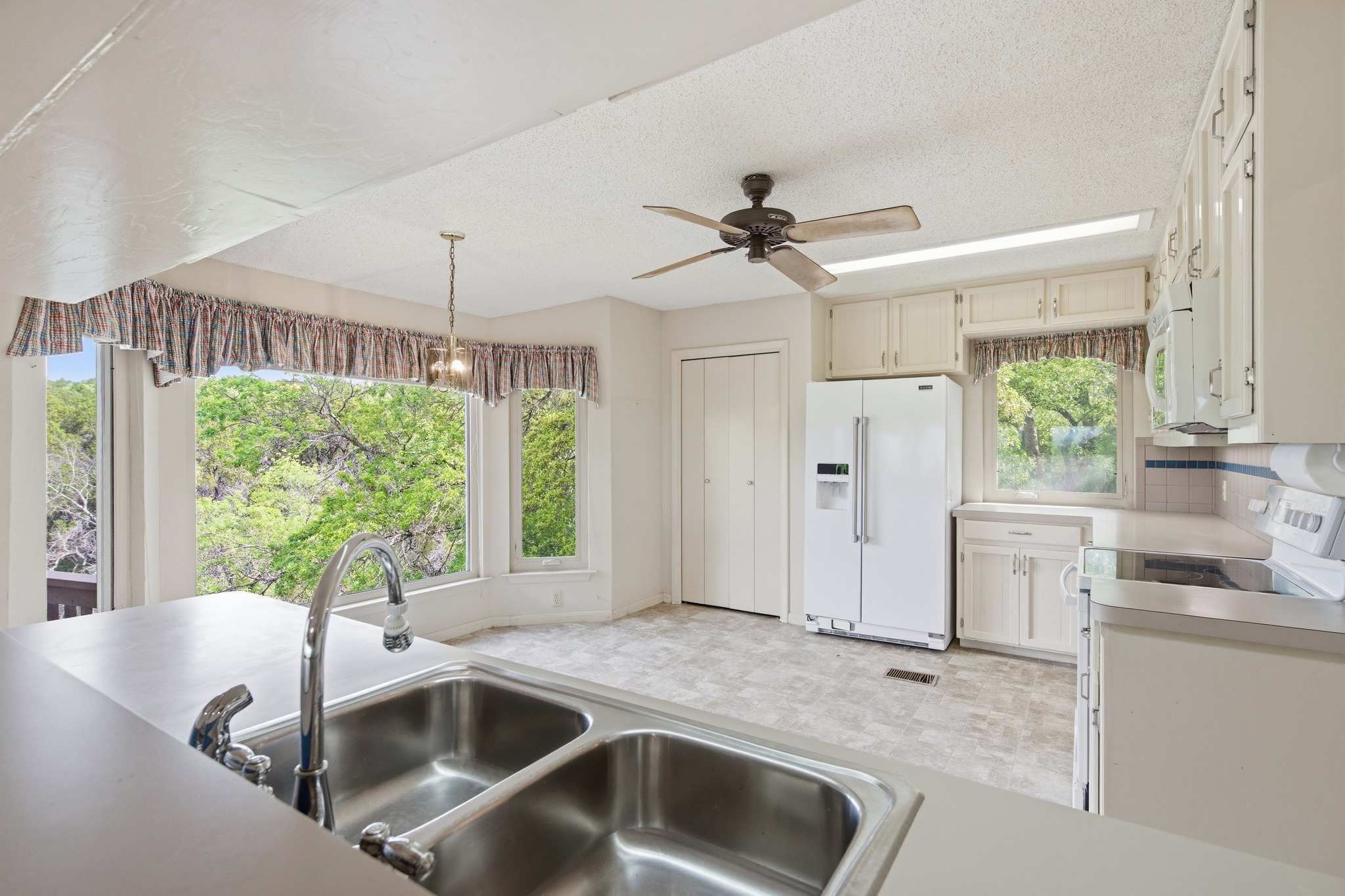 4831 Eck Lane Austin, TX 78734 - Photo 15 of 27 a kitchen with a stove a sink and a refrigerator