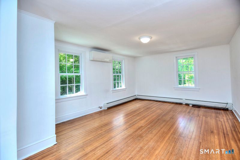 94 Honey Hill Road Wilton, CT 06897 - Photo 4 of 18 an empty room with wooden floor and windows