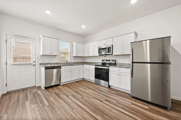 a kitchen with white cabinets stainless steel appliances