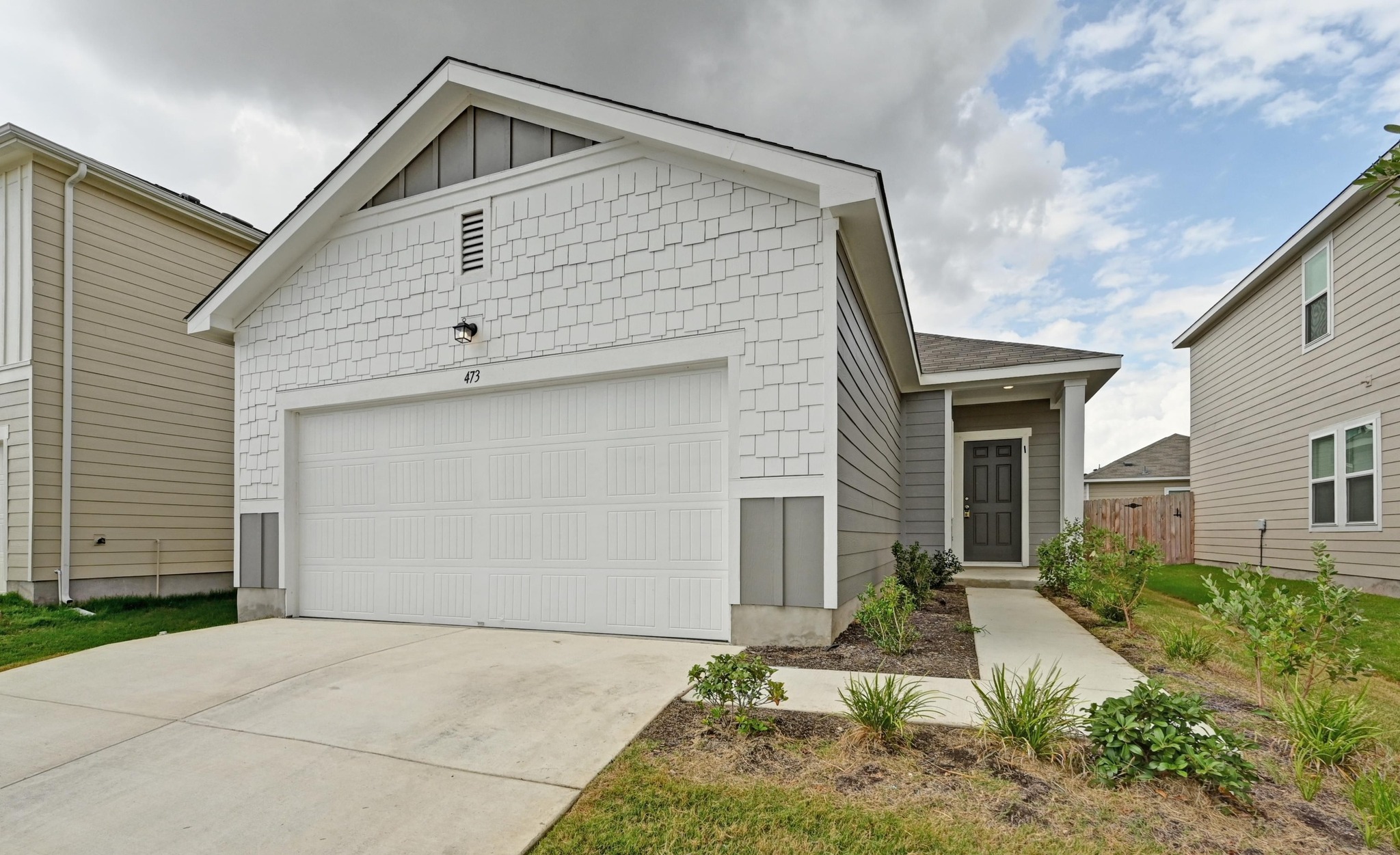 473 Thistle Lane Maxwell, TX 78656 - Photo 4 of 25 View of front of house featuring concrete driveway, an attached garage, and board and batten siding
