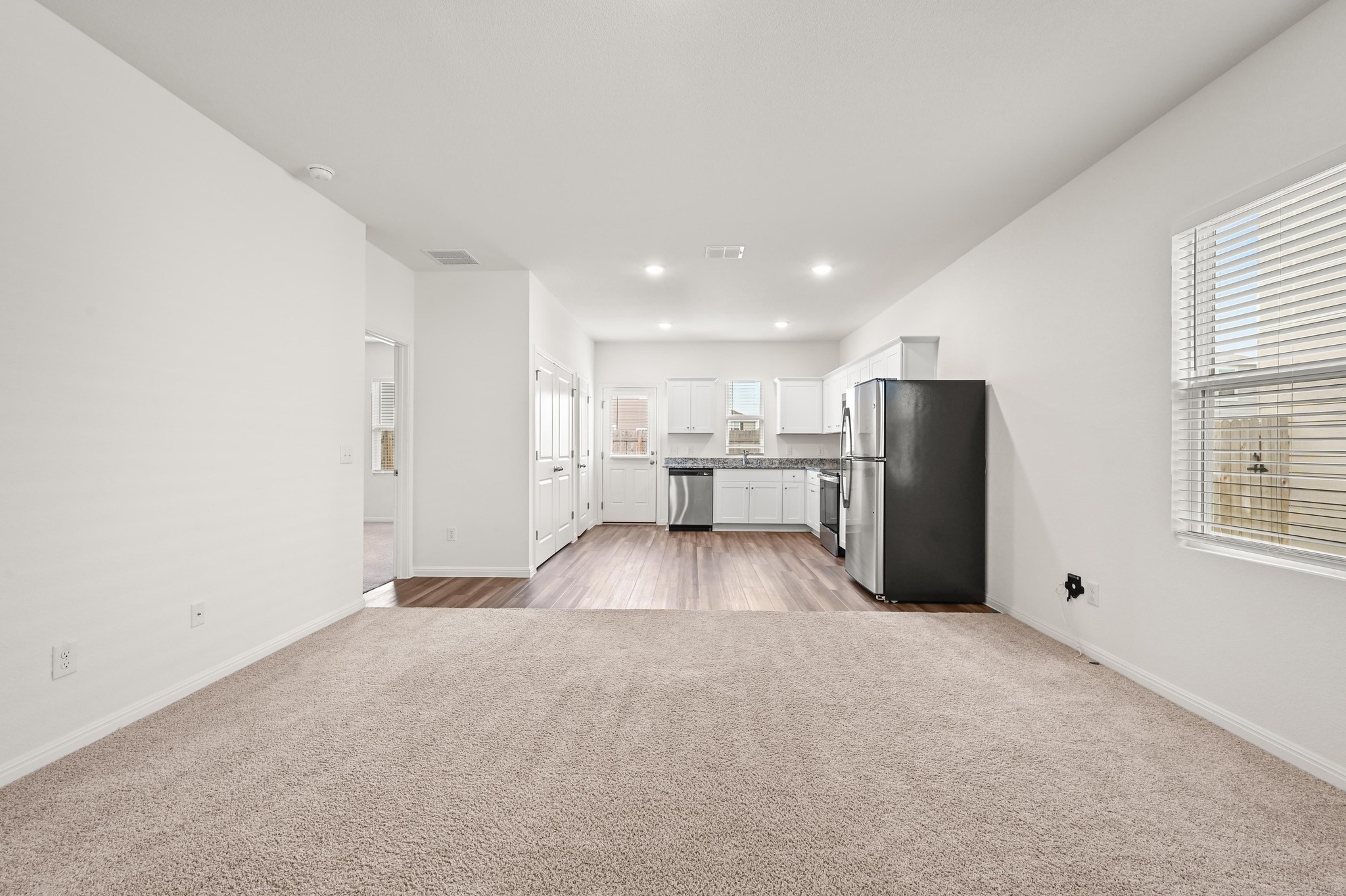 473 Thistle Lane Maxwell, TX 78656 - Photo 6 of 25 Unfurnished living room with light colored carpet and recessed lighting