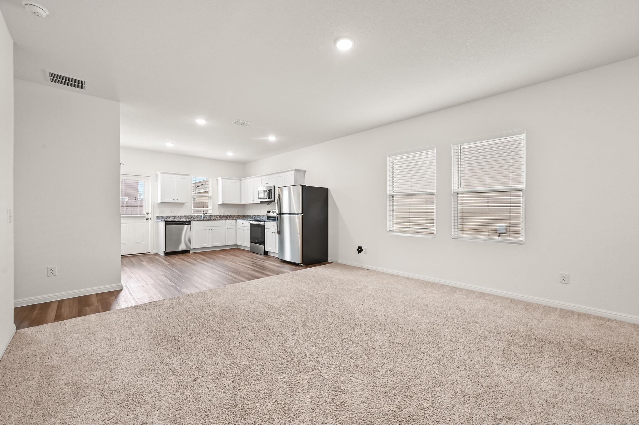 473 Thistle Lane Maxwell, TX 78656 - Photo 25 of 25 Kitchen featuring white cabinets, open floor plan, stainless steel appliances, light carpet, and recessed lighting
