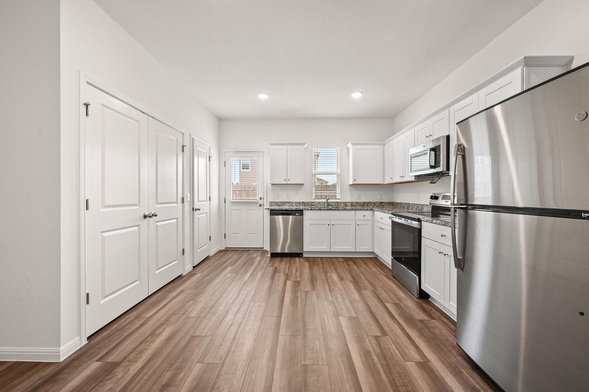 473 Thistle Lane Maxwell, TX 78656 - Photo 9 of 25 Kitchen featuring stainless steel appliances, white cabinets, dark wood-style floors, and recessed lighting