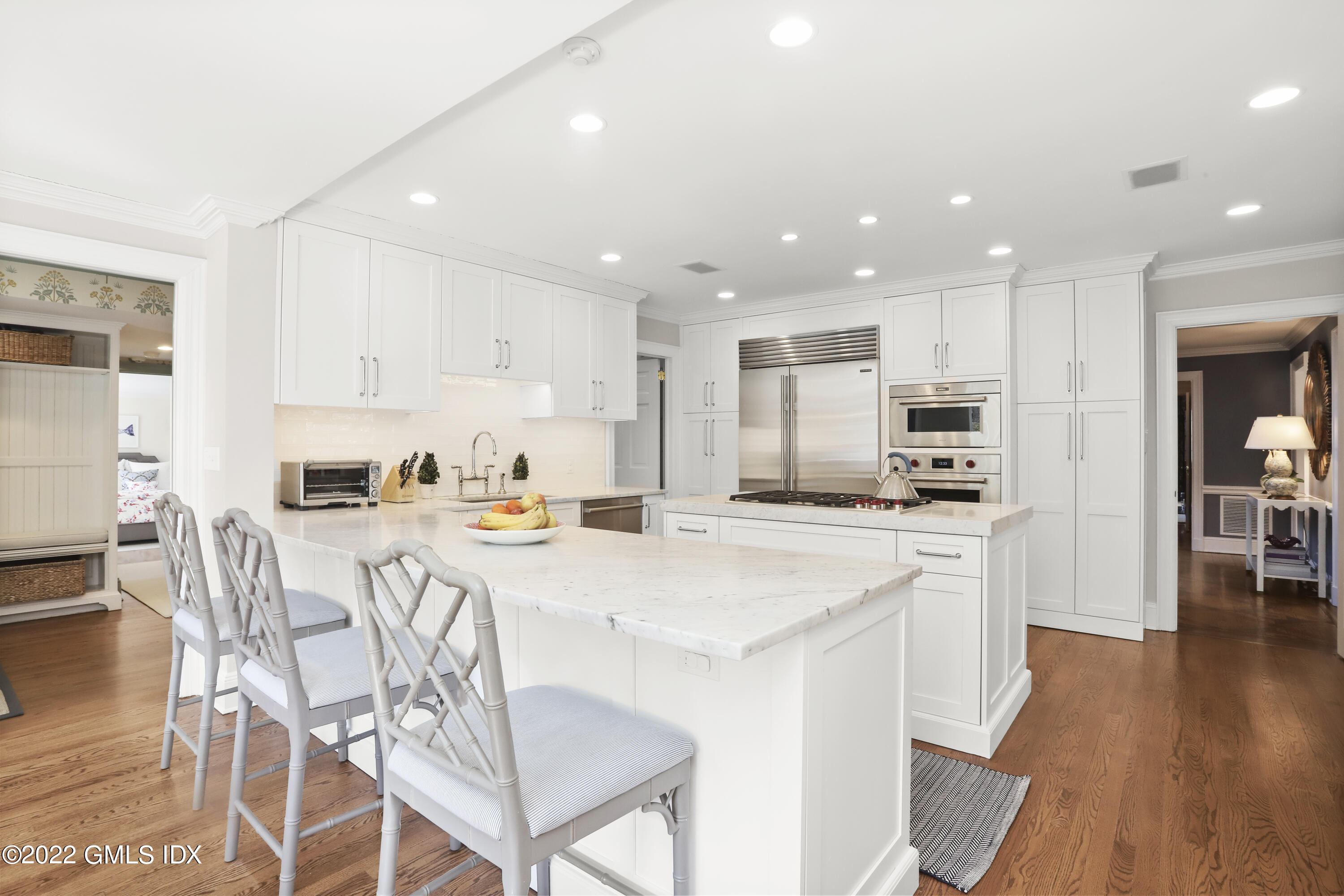 144 Pecksland Road Greenwich, CT 06831 - Photo 16 of 49 a kitchen with stainless steel appliances granite countertop a stove top oven a sink a refrigerator and white cabinets with wooden floor
